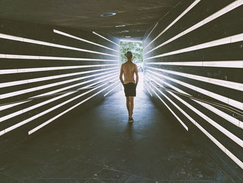 Rear view of man walking in corridor