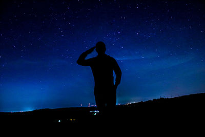 Silhouette man standing against sky at night