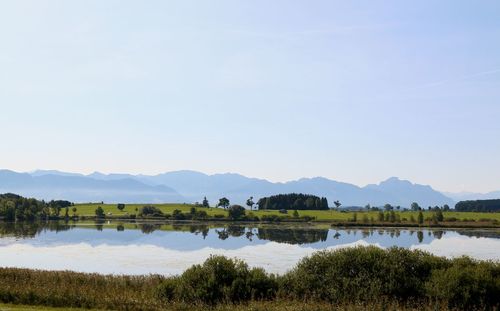 Scenic view of lake and mountains against clear sky