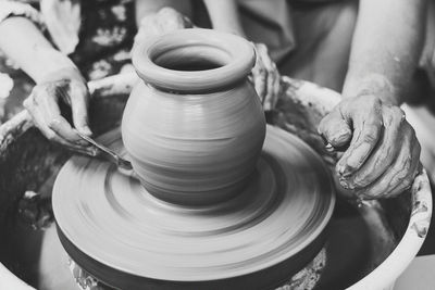 Cropped hands of potter making pot at workshop