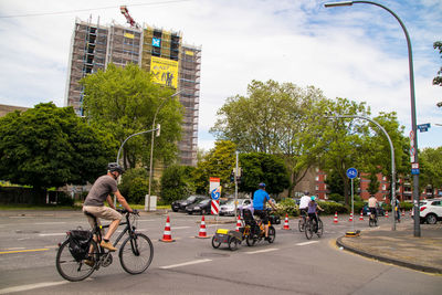 People riding bicycles on road in city