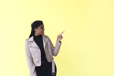 Young woman looking away against gray background