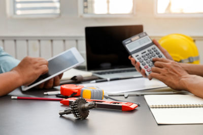 Midsection of man using mobile phone on table