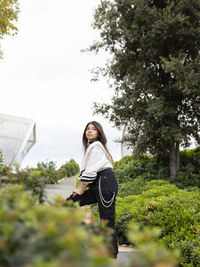 Full length of woman standing by plants