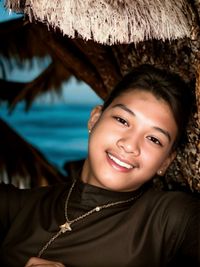 Portrait of young woman sitting at beach