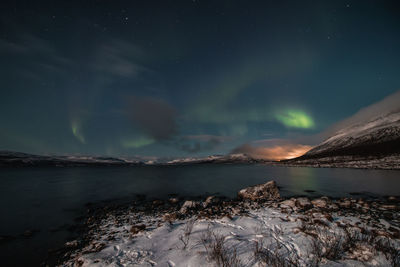 Scenic view of snowcapped mountains against sky at night