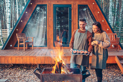 Young couple standing against fire