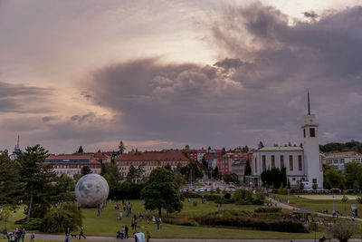 Trees and buildings against sky during sunset