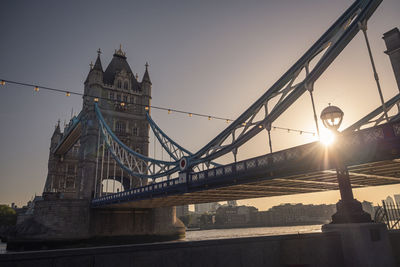 Low angle view of tower bridge against sky during sunrise 