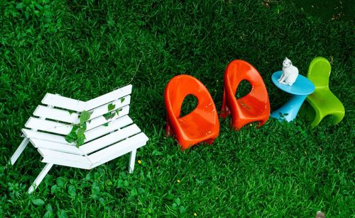 High angle view of empty benches on grass