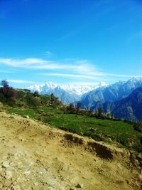 Scenic view of landscape and mountains against blue sky