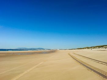 Scenic view of desert against clear blue sky