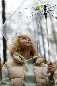 Portrait of young woman standing against sky