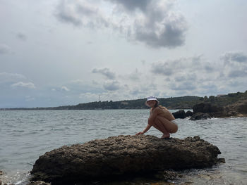 Woman sitting on the rock at the beach