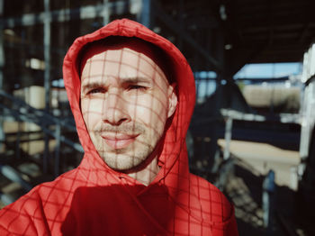 Portrait of man standing against red wall