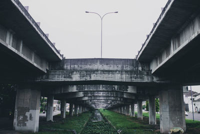 Bridge over empty road against sky