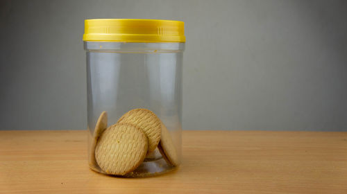 Close-up of jar on table against wall