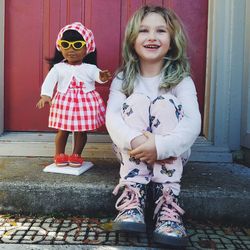 Smiling girl standing against wall