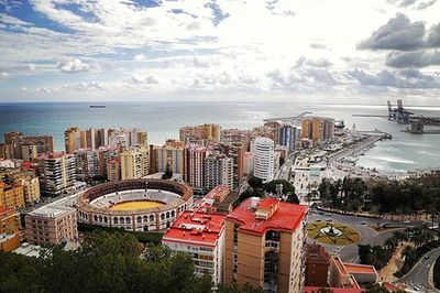 View of cityscape against cloudy sky