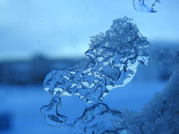Close-up of frozen water against blue sky