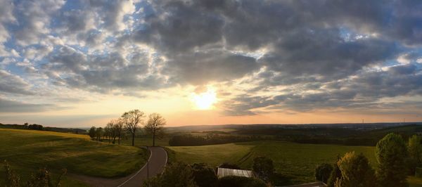 Scenic view of field against sky at sunset