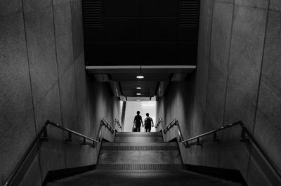 High angle view of people moving down steps in subway