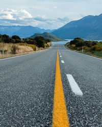 Surface level of road amidst mountains against sky