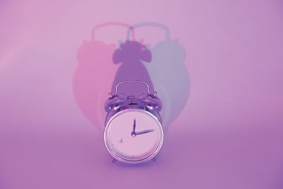 Close-up of alarm clock on purple background