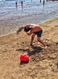 Full length of shirtless boy on beach