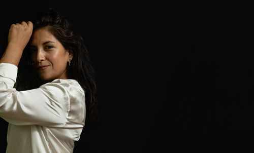 Young woman standing against black background