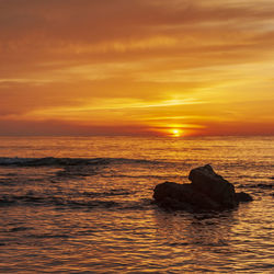 Scenic view of sea against orange sky