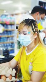 Woman wearing mask working at supermarket