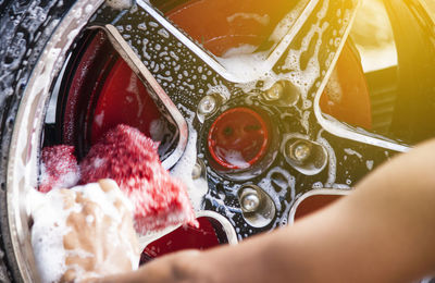 Close-up of hands cleaning alloy wheels