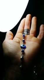 Cropped hand holding evil eye bracelet