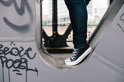 Low section of person standing on metal structure