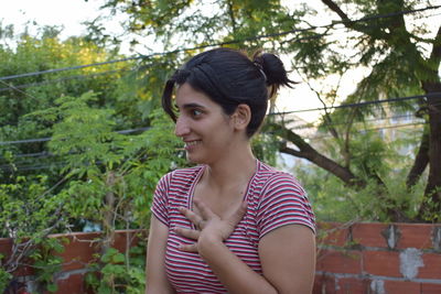 Shocked woman looking away against trees