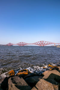 Bridge over sea against clear sky