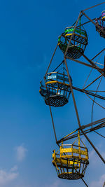 Low angle view of ferris wheel against blue sky