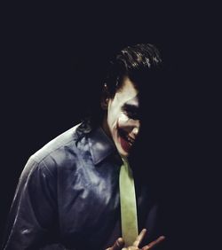 Portrait of young man against black background