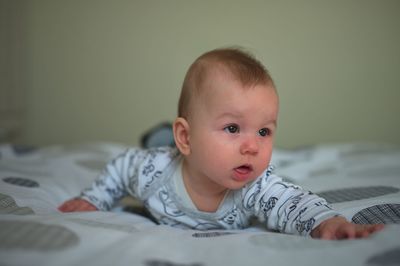 Newborn baby in pajamas relaxing in bed