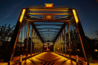 Illuminated bridge against sky at night