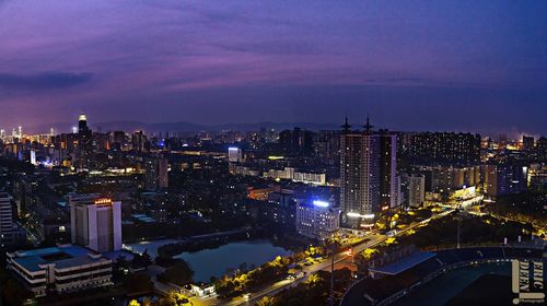 Illuminated cityscape against sky at night