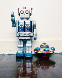 Close-up of toys on table against wall