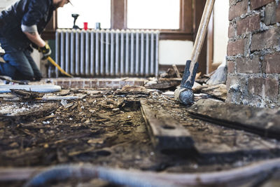 Side view of man kneeling by radiator in abandoned house