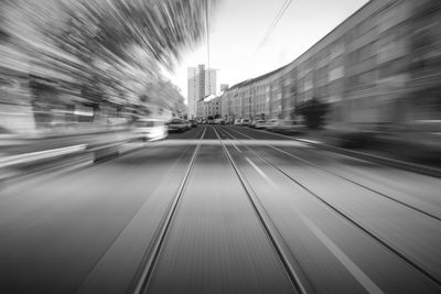 Blurred motion of railroad tracks amidst buildings in city