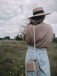 Rear view of woman standing on field