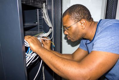 Side view of man working with wires