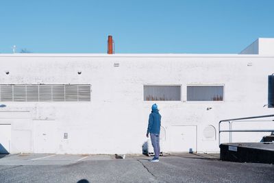 Rear view of man standing against building