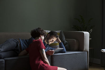 Couple relaxing together in the living room looking at tablet