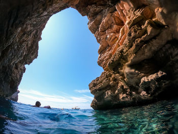 Rock formation in sea against sky